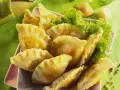 Goldbraune Pierogi, frisch zubereitet nach einem tollen Pierogi Rezept, serviert mit Salat.
