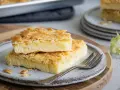 Zwei Stücke saftiger Butterkuchen mit knuspriger Mandelkruste auf einem Teller, bereit zum Genießen. Ein köstliches butterkuchen rezept.