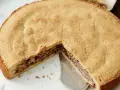 Eine köstliche Engadiner Nusstorte mit goldbraunem Teig und einer reichhaltigen Nussfüllung, gerade angeschnitten.