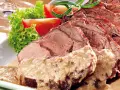 Saftiger Sauerbraten, perfekt für Ihr nächstes Sauerbraten Rezept, serviert mit frischem Salat und Tomaten.