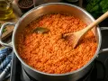 Ein Topf mit köstlichem Tomatenreis, bereit für das nächste Tomatenreis Rezept. Ein Lorbeerblatt liegt obenauf.