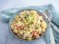 Schüssel mit cremigem Nudelsalat, garniert mit Petersilie. Das cremige nudelsalat dressing macht ihn unwiderstehlich.