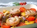 Bratwurst-Ringe mit Kartoffeln, Tomaten und Rosmarin im Ofen gebacken.