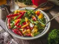Bunter Paprika Salat mit frischer Petersilie, serviert auf einem rustikalen Holztisch.
