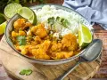 Herzhaftes Curry mit Blumenkohl und Reis, garniert mit Limettenspalten. Ein köstliches Beispiel für Blumenkohl Rezepte.
