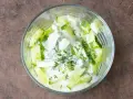 Erfrischender Gurkensalat mit Joghurt und Dill in einer Glasschüssel, bereit zum Genießen.