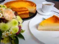 Ein köstliches Eierschecke-Rezept: Ein goldbrauner Kuchen mit cremiger Füllung, daneben eine Tasse Kaffee und ein Blumenstrauß.