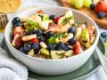Ein bunter Obstsalat mit Erdbeeren, Blaubeeren, Bananen und Äpfeln, perfekt für ein leichtes obstsalat rezept.