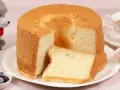 Ein luftiger Chiffon-Kuchen mit einer Scheibe daneben, serviert mit Beeren und Tee.