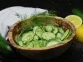 Frischer Gurkensalat im Holzschälchen, garniert mit Dill. Ein einfaches gurkensalat rezept für den Sommer.