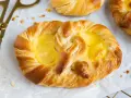 Goldene puddingbrezeln, frisch gebacken, warten auf das puddingbrezel rezept. Daneben liegt eine goldene Zange.