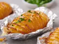 Leckere Hasselback-Kartoffeln, bestreut mit Käse und Petersilie. Ein einfaches Gericht aus der Kategorie Kartoffel Rezepte.