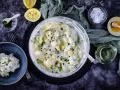 Cremiger Kartoffelsalat mit Joghurt, garniert mit Schnittlauch. Dazu Zitrone, Honig und grobes Salz.