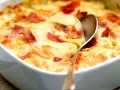 Schinken Sahne Auflauf ohne Vorkochen: Kartoffelscheiben mit Schinken und cremiger Sauce im Auflauf, bereit zum Servieren.