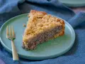 Ein saftiges Stück Mohnkuchen mit Streuseln auf einem mintgrünen Teller, daneben eine goldene Gabel. Ein köstliches Mohnkuchen Rezept.