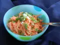 Karottensalat mit cremigem karottensalat dressing und Frühlingszwiebeln in einer bunten Schüssel.