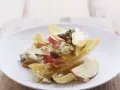 Ein köstlicher chicoree salat mit Äpfeln, Birnen, Blauschimmelkäse und Walnüssen auf einem weißen Teller.