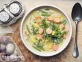 Herzhafte Bohnen-Kartoffel-Suppe mit Würstchen, ein Klassiker unter den Bohnen Rezepten. Dazu Salz- und Pfefferstreuer und frischer Knoblauch.