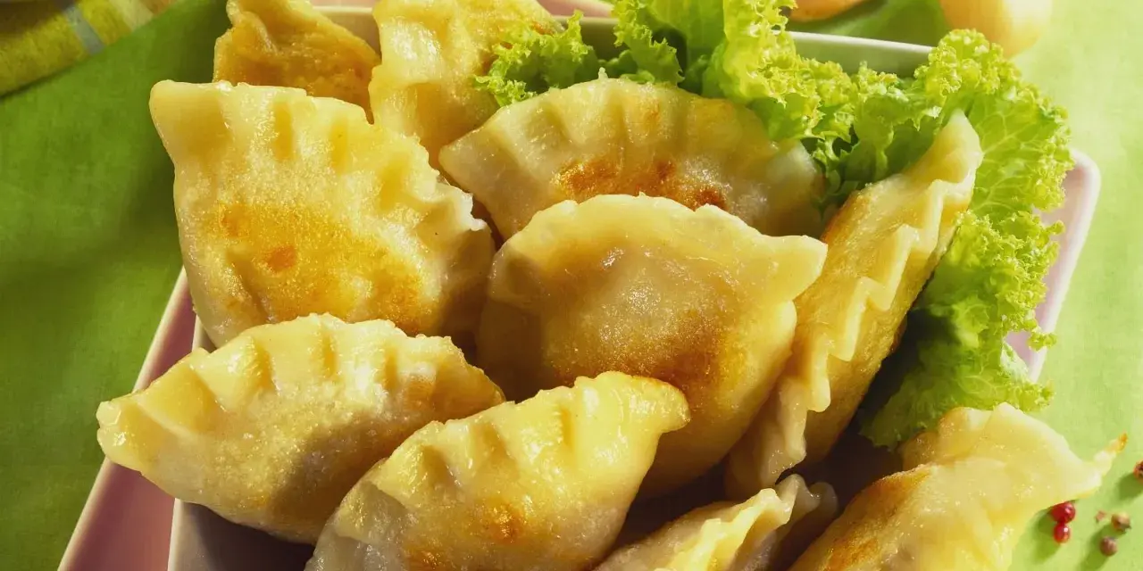 Goldbraune Pierogi, frisch zubereitet nach einem tollen Pierogi Rezept, serviert mit Salat.