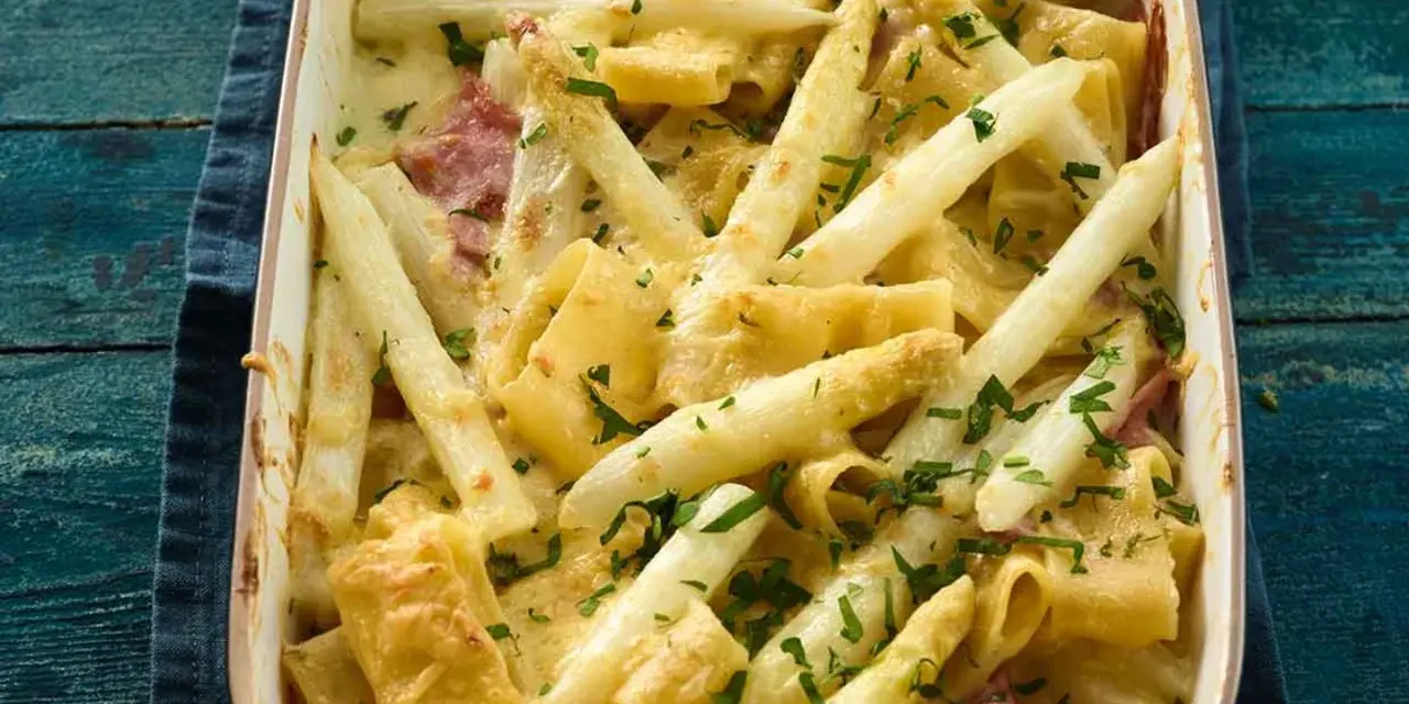 Ein cremiger Spargel Nudel Auflauf mit Schinken und frischer Petersilie, goldbraun überbacken.