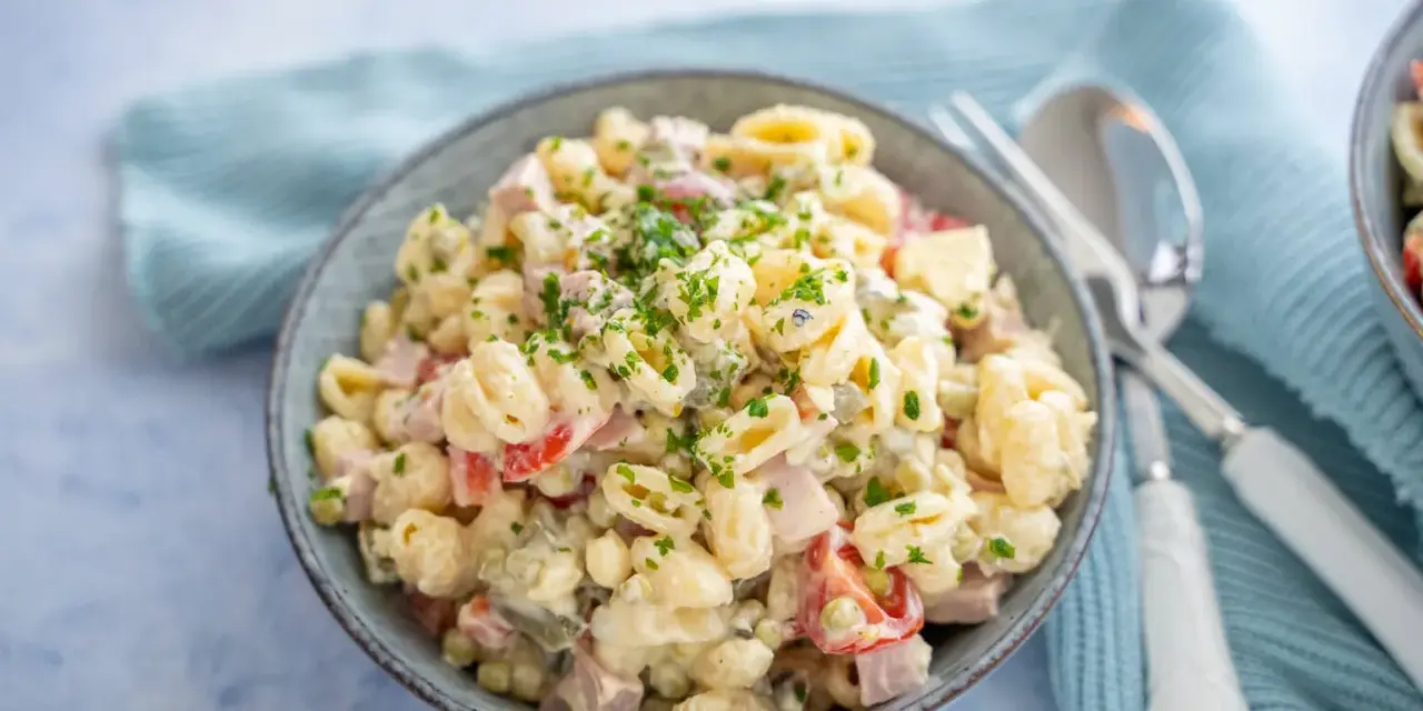 Schüssel mit cremigem Nudelsalat, garniert mit Petersilie. Das cremige nudelsalat dressing macht ihn unwiderstehlich.