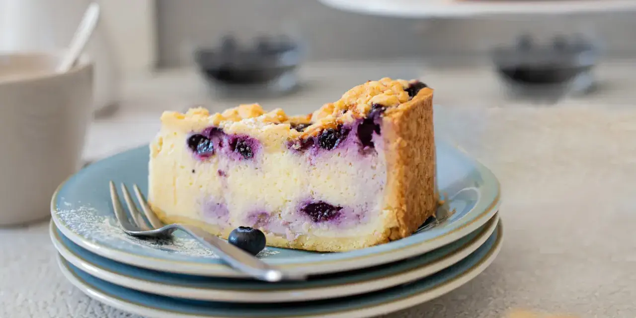 Ein Stück cremiger Blaubeerkuchen mit Streuseln, perfekt für ein Blaubeerkuchen Rezept.