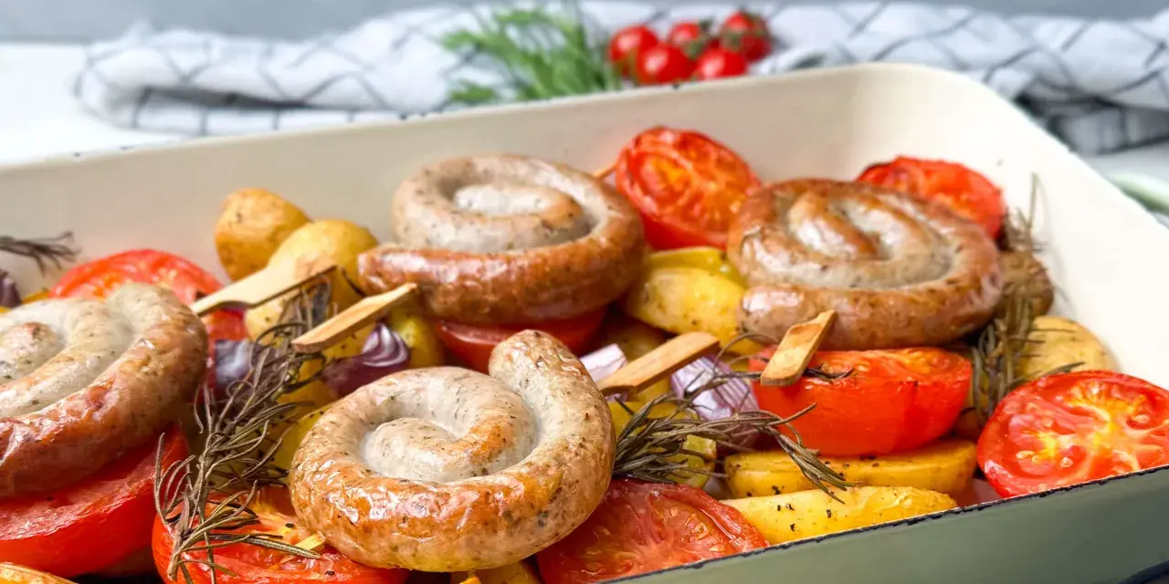Bratwurst-Ringe mit Kartoffeln, Tomaten und Rosmarin im Ofen gebacken.