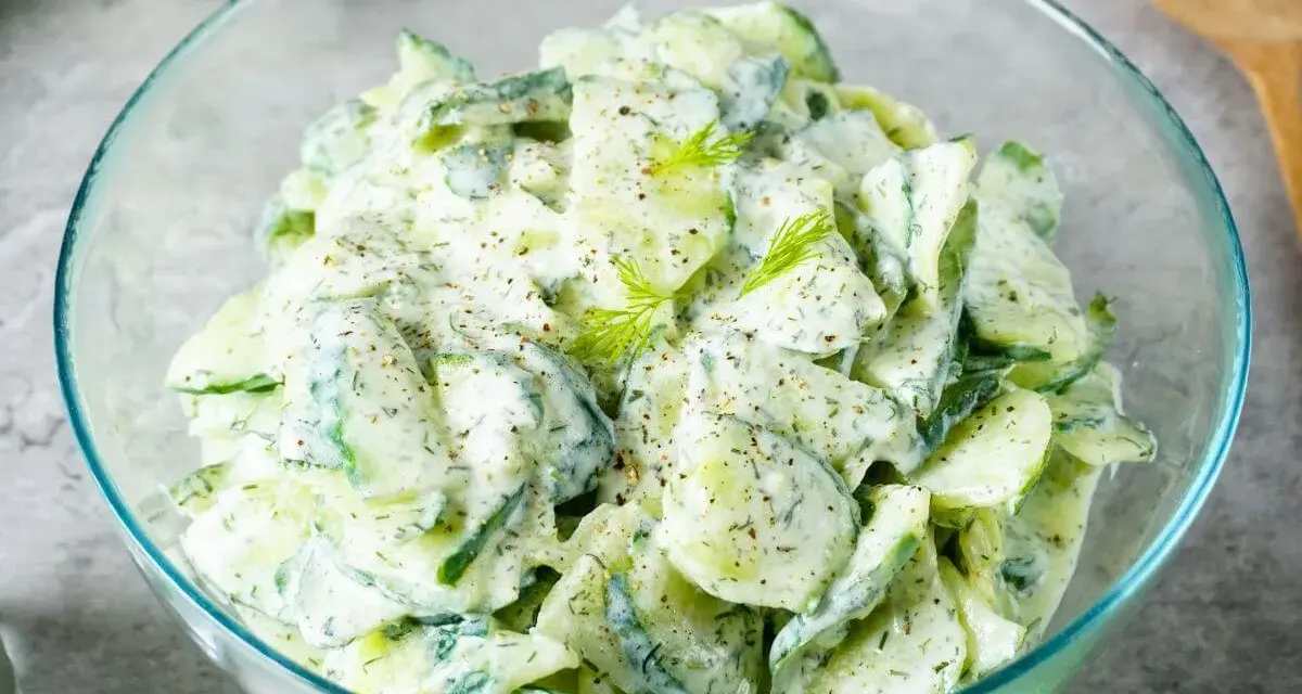 Frischer Gurkensalat mit cremigem Dressing und Dill, garniert mit Pfeffer. Ein leichter Genuss!