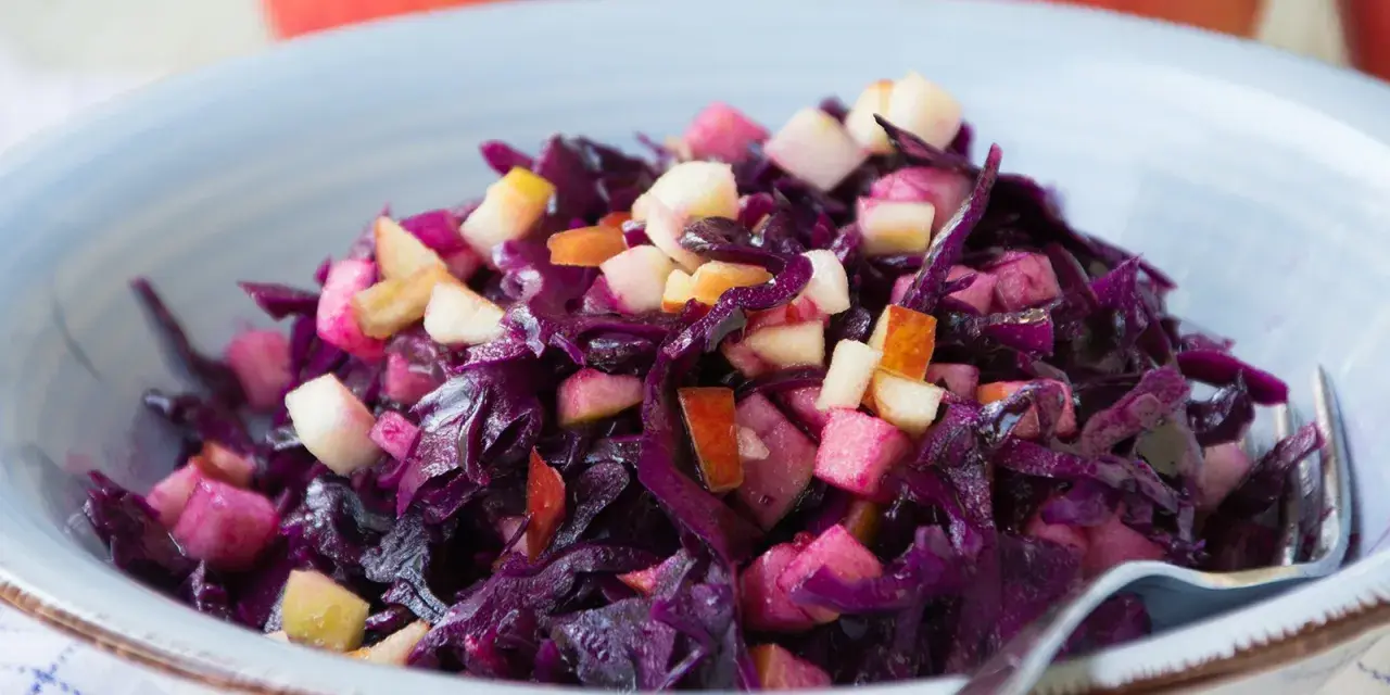 Schüssel mit leckerem rotkohl salat und Apfelstücken. Ein Klassiker, der immer schmeckt.