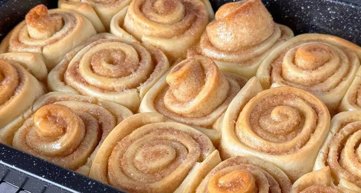 Frisch gebackene Zimtschnecken in einer Backform, goldbraun und duftend.
