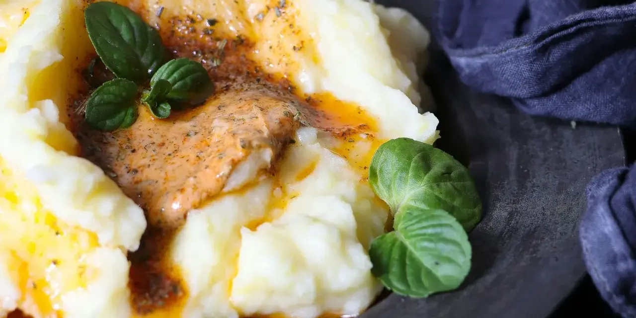 Cremiger Kartoffelbrei mit einer würzigen Sauce und frischen Kräutern. Ein einfaches Kartoffelbrei Rezept, das jeder nachmachen kann.