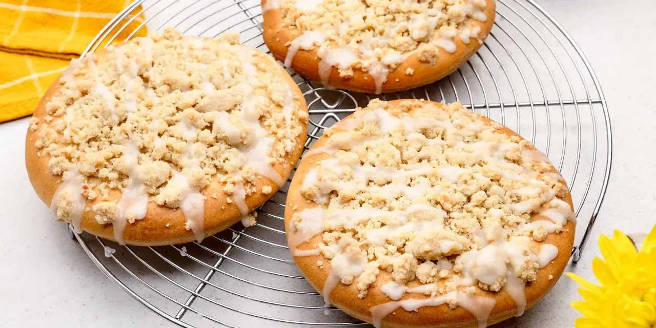 Drei runde Streusel Taler mit Zuckerguss auf einem Kuchengitter, bereit zum Genießen.