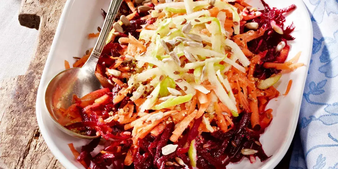 Bunter Rote Bete Salat mit geraspelten Karotten und Apfel, bestreut mit Sonnenblumenkernen und Leinsamen.