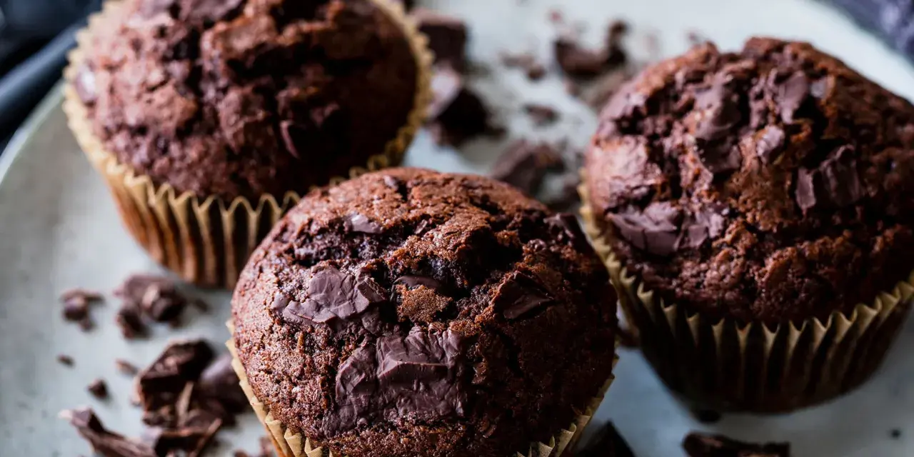 Drei saftige Schokomuffins mit Schokoladenstückchen, perfekt für ein schnelles schokomuffins rezept.