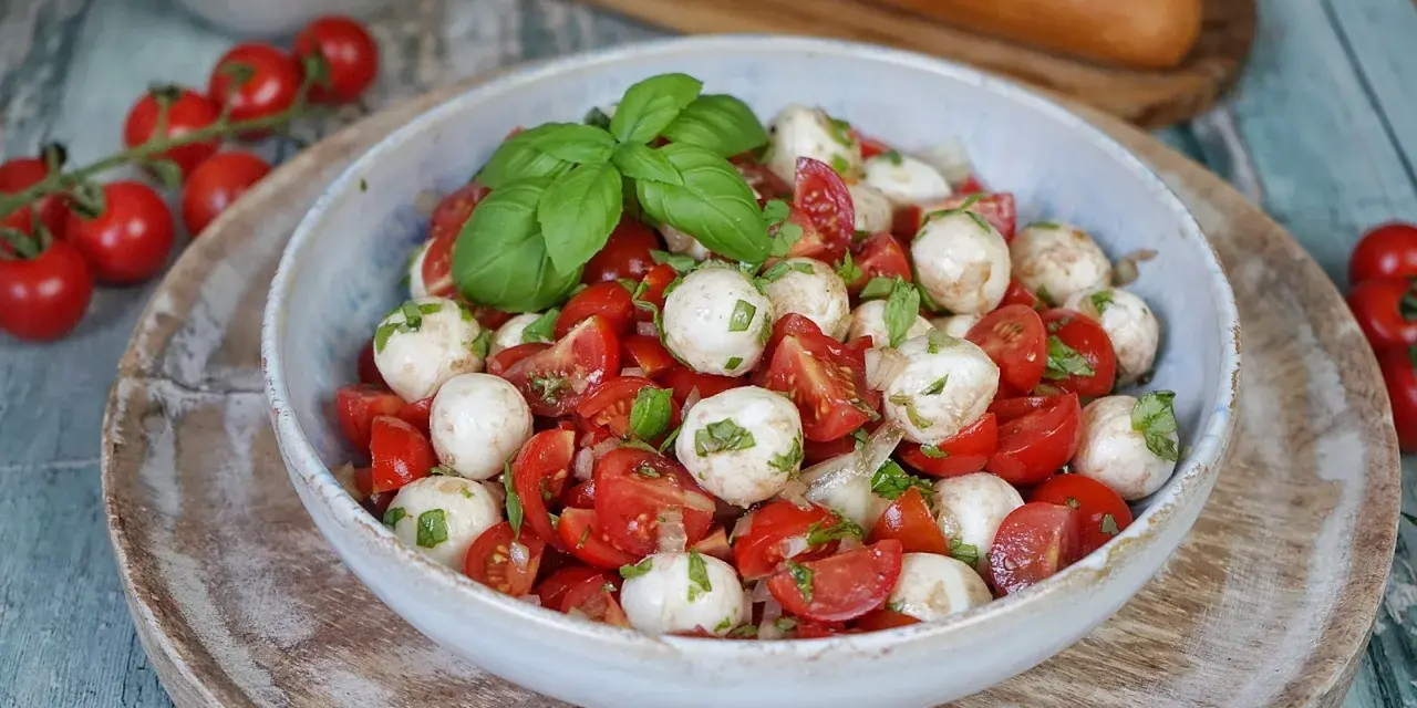 Tomate Mozzarella Salat mit frischem Basilikum und einem leichten Dressing. Perfekt als leichte Mahlzeit.