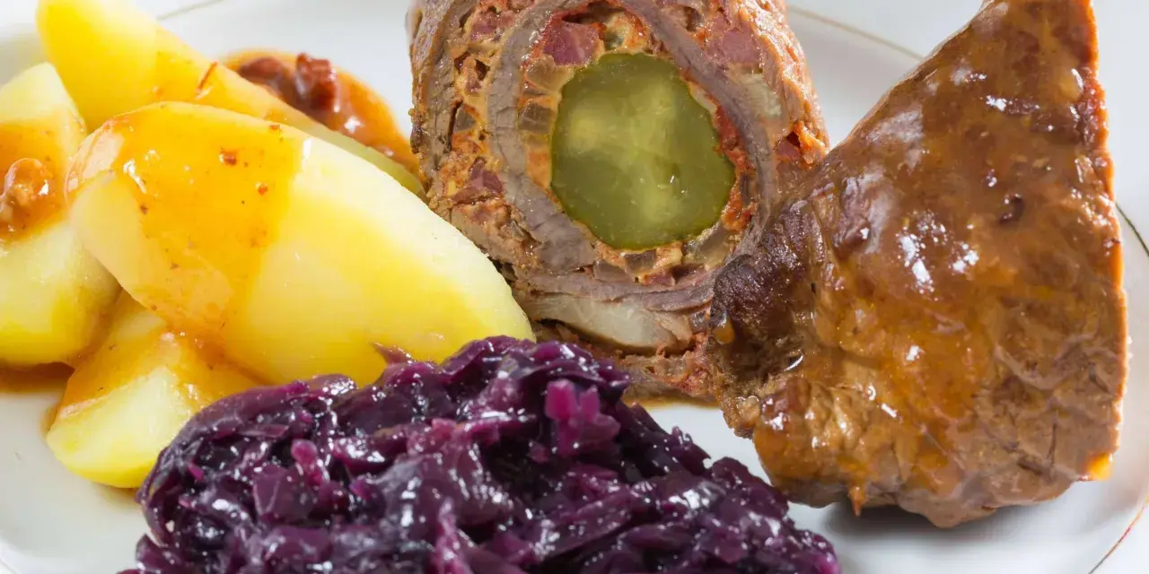 Rinderrouladen mit Rotkohl und Kartoffeln, ein deftiges Gericht, das nach Hausmannskost schmeckt.