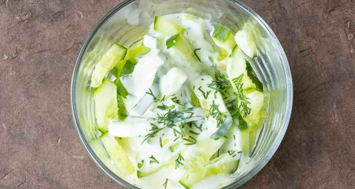 Erfrischender Gurkensalat mit Joghurt und Dill in einer Glasschüssel, bereit zum Genießen.