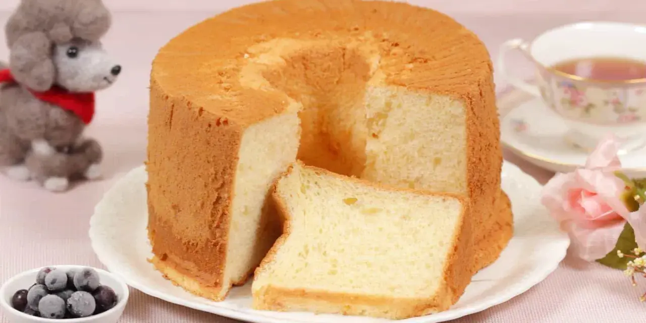 Ein luftiger Chiffon-Kuchen mit einer Scheibe daneben, serviert mit Beeren und Tee.
