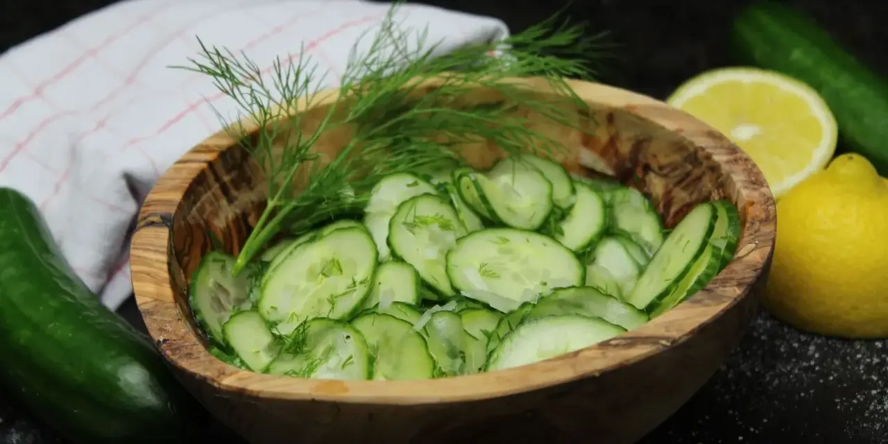 Frischer Gurkensalat im Holzschälchen, garniert mit Dill. Ein einfaches gurkensalat rezept für den Sommer.