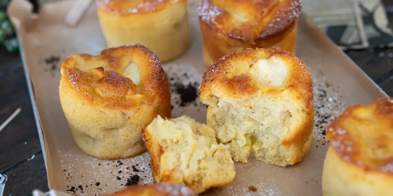 Saftige Apfelmuffins, perfekt für ein schnelles apfelmuffins rezept. Einer ist aufgeschnitten und zeigt die fruchtige Füllung.