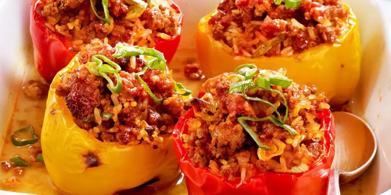 Gefüllte Paprika mit Hackfleisch und Reis, garniert mit Frühlingszwiebeln. Ein Klassiker der Paprika Rezepte.