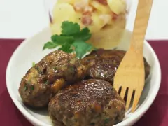Saftige Frikadellen mit cremigem Kartoffelsalat, garniert mit Petersilie. Ein klassisches Gericht, das immer schmeckt.