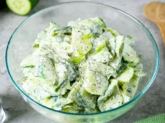 Frischer Gurkensalat mit cremigem Dressing und Dill, garniert mit Pfeffer. Ein leichter Genuss!