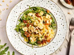 Mediterraner Salat mit Farfalle, getrockneten Tomaten, Rucola und Pinienkernen. Ein leichter Genuss!