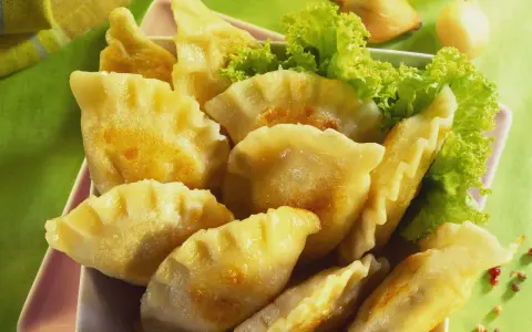 Goldbraune Pierogi, frisch zubereitet nach einem tollen Pierogi Rezept, serviert mit Salat.