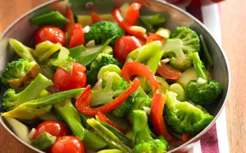 Buntes Gemüse aus Brokkoli, Tomaten und Paprika in einer Pfanne, perfekt für ein schnelles und gesundes Rezept.