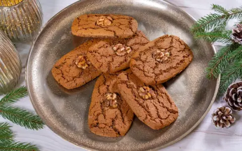 Aachener Printen Rezept: Köstliche, nussgekrönte Printen auf einem silbernen Teller, umgeben von Tannenzweigen und Zapfen. Perfekt für die Weihnachtszeit.