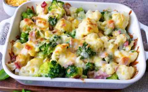Ein köstlicher Blumenkohlauflauf mit Brokkoli und Schinken, überbacken mit geschmolzenem Käse.