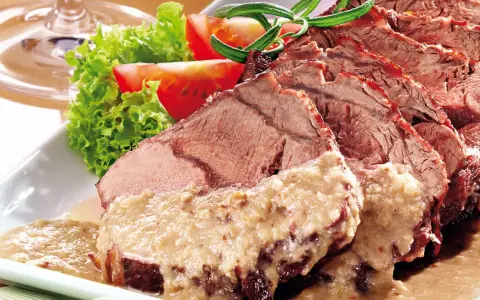 Saftiger Sauerbraten, perfekt für Ihr nächstes Sauerbraten Rezept, serviert mit frischem Salat und Tomaten.