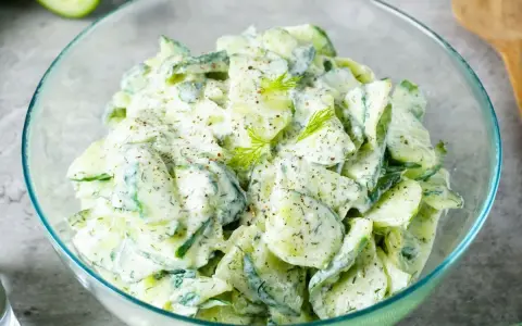 Frischer Gurkensalat mit cremigem Dressing und Dill, garniert mit Pfeffer. Ein leichter Genuss!